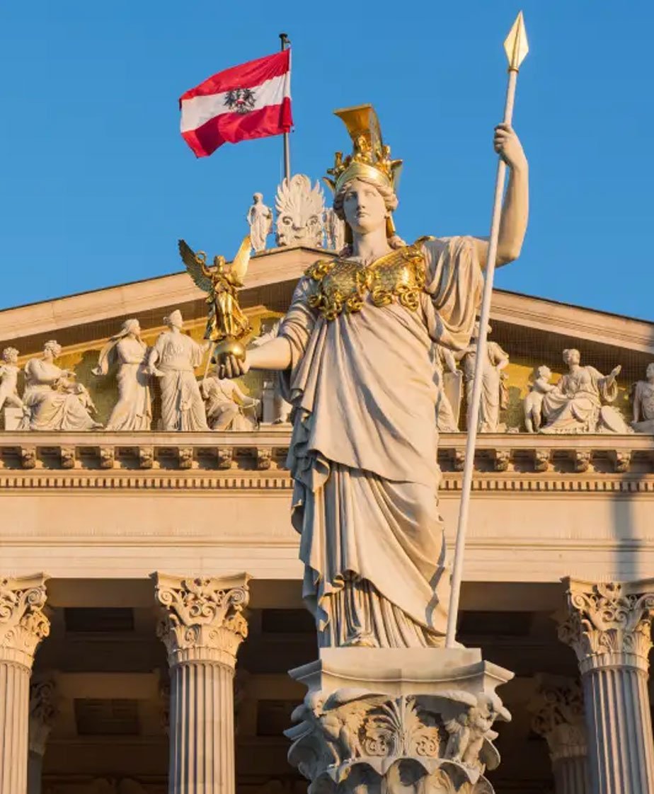a statue of a woman holding a staff in front of a building