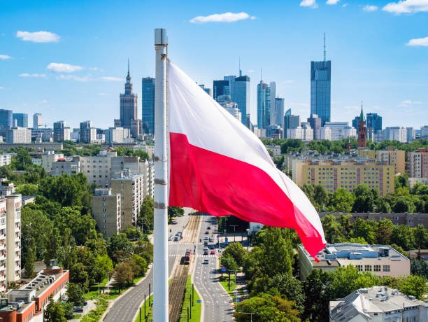 Polish national flag waving over Warsaw city skyline, representing Poland visit visa services from Dubai