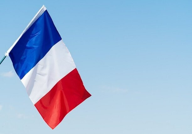 French flag waving under blue sky – France visa consultants in Dubai